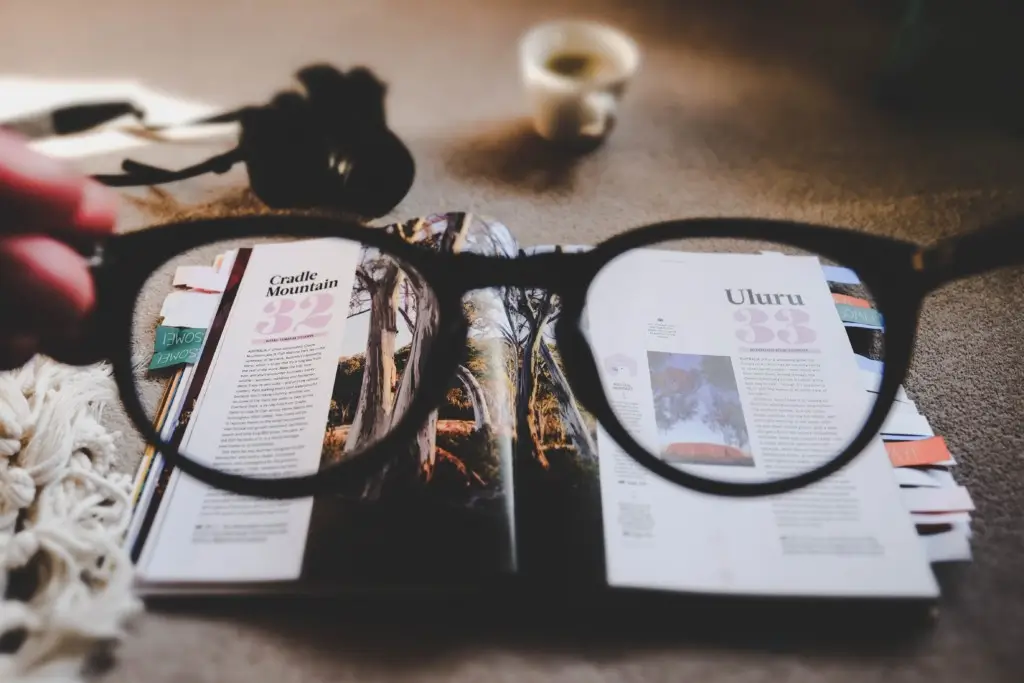Reading glasses magnify underlying text of a magazine