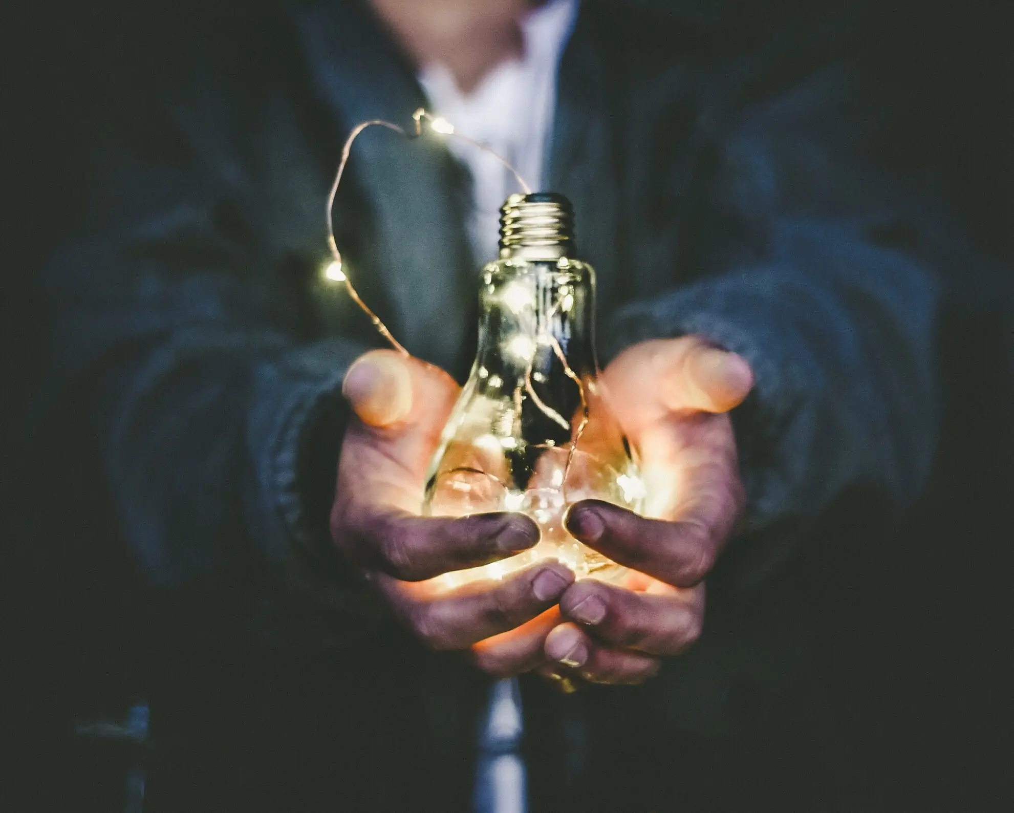 Man holding an illuminated lightbulb 