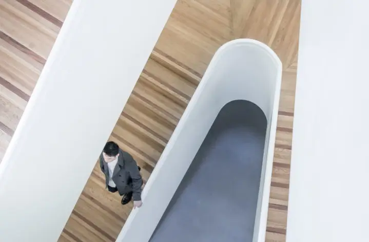Looking down a staircase at a man walking down.
